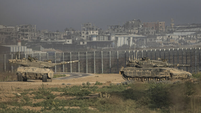 Tanks seen in foreground, border wall seen in background. 