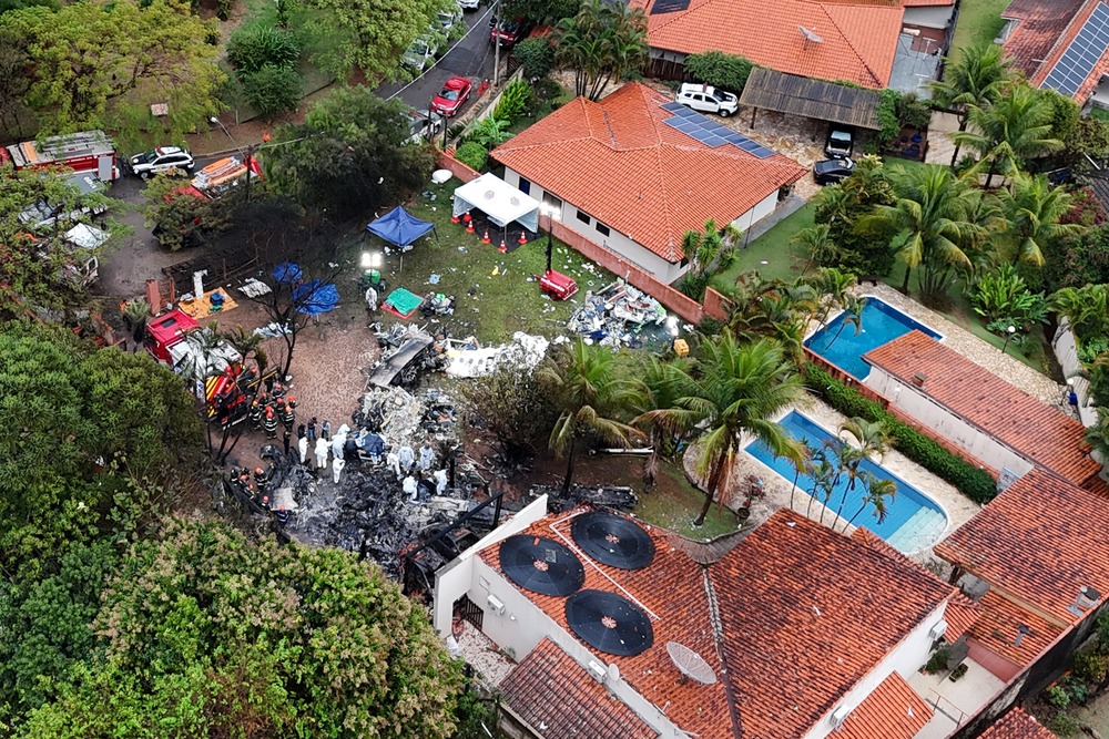 Aerial view of smoldering wreckage in middle of residential area. 