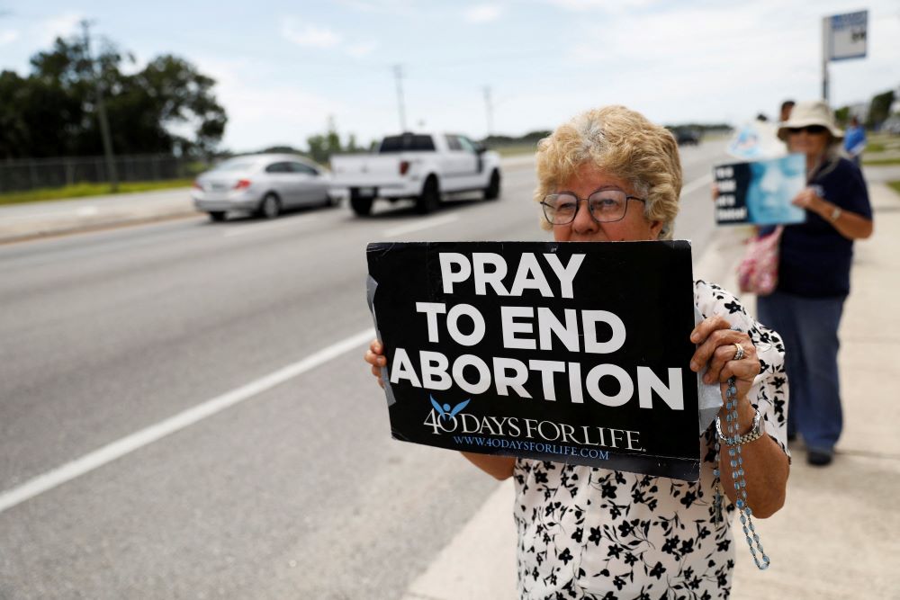 Woman holds pro-life sign.