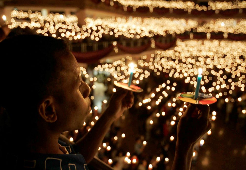 A Christian holds candles during Christmas prayers at Bethany Church in Surabaya, Indonesia, Dec. 25, 2007. 