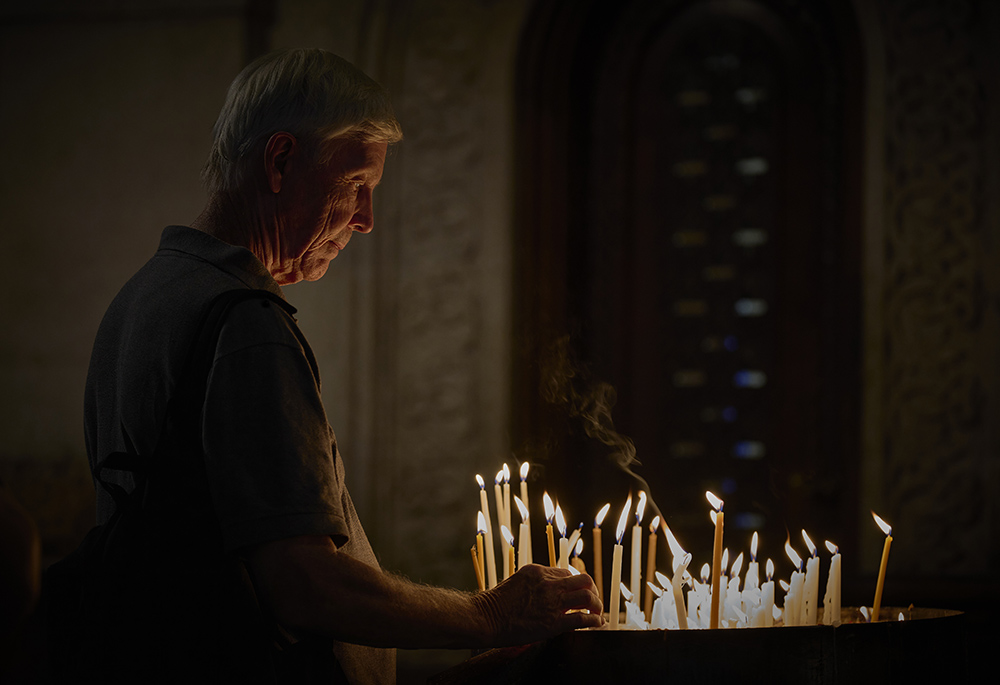 Scott Wright, a member of Pax Christi USA, lights a candle in Jerusalem's Church of the Holy Sepulcher Aug. 14. Wright and other members of a visiting delegation of U.S. church activists came to the Middle East to accompany threatened Christians and other Palestinians and call for a cease-fire in Gaza. (Life on Earth Pictures/Paul Jeffrey/)