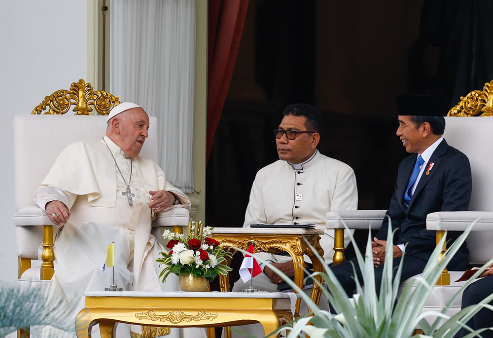 Pope Francis and Indonesian President Joko Widodo meet on the veranda of Merdeka Palace, the official presidential residence Sept. 4 in Jakarta, Indonesia. Divine Word Fr. Markus Solo Kewuta, an Indonesian official at the Vatican Dicastery for Interreligious Dialogue, center, translates for the pope. (CNS/Lola Gomez)