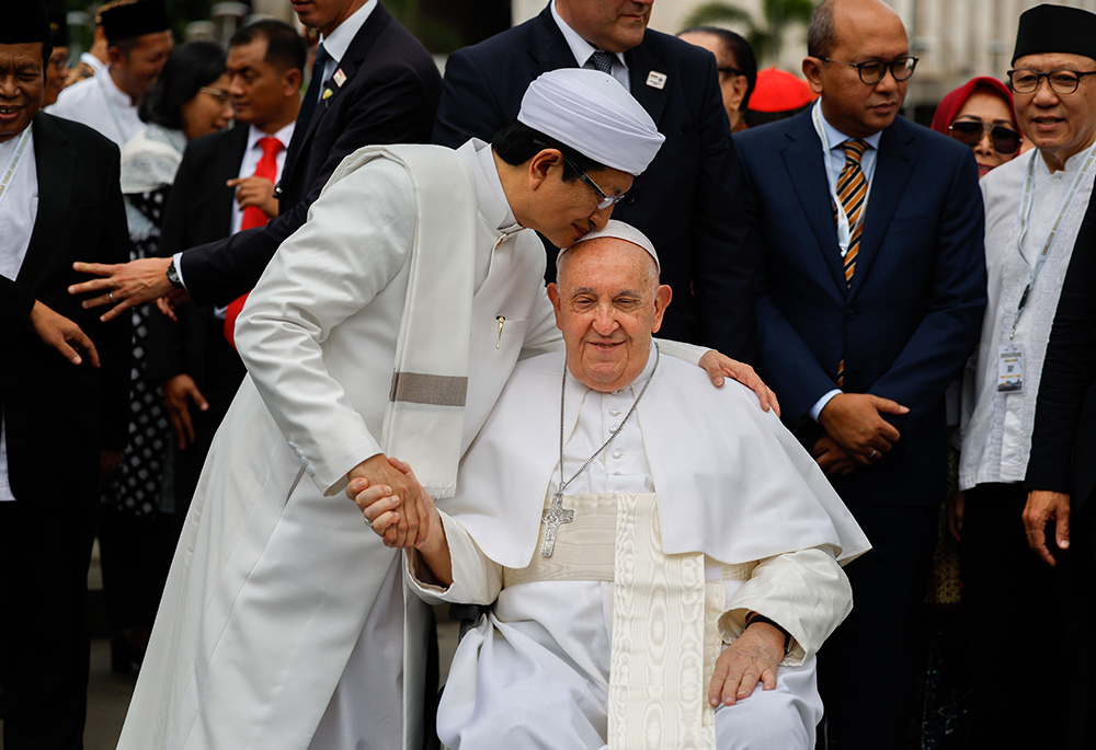 Nasaruddin Umar, grand imam of the Istiqlal Mosque in Jakarta, Indonesia, kisses Pope Francis on the top of the head at the conclusion of an interreligious meeting Sept. 5. (CNS/Lola Gomez)