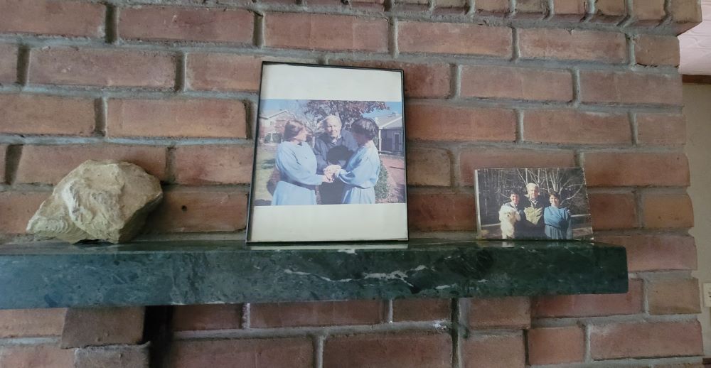 Early photos of Green Mountain Monastery cofounders Srs. Gail Worcelo and Bernadette Bostwick, and Fr. Thomas Berry adorn a fireplace mantel at the monastery. (GSR photo/Gail DeGeorge)