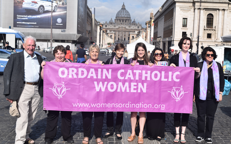 From left to right: Irish Redemptorist Fr. Tony Flannery, Polish activist Alicja Baranowska, British activist Pat Brown, U.S. Anglican Rev. Dana English, Kate McElwee, Erin Saiz Hanna, Miriam Duignan and Jamie Manson hold a sign supporting women's ordination in front of St. Peter's Basilica on June 3, 2016. (NCR photo)