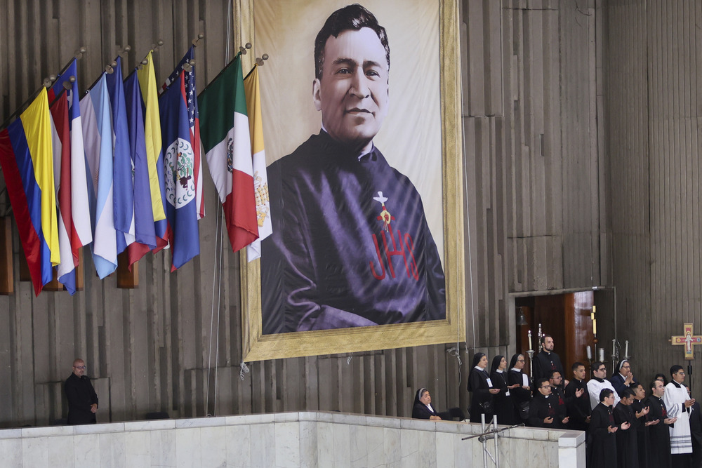 Large banner hangs on wall beside various flags. 