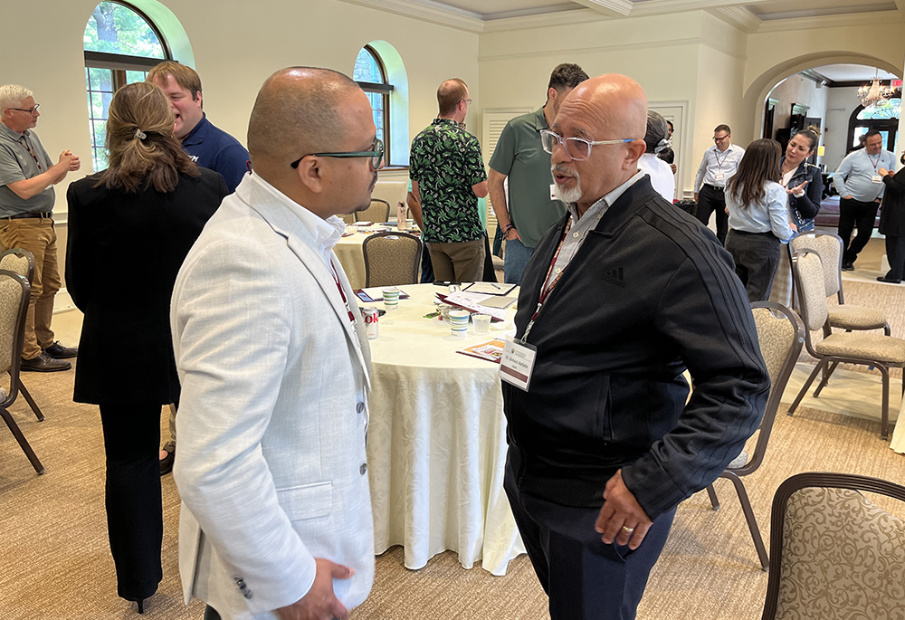 Federación de Institutos Pastorales president Peter Joseph Ductrám, left, and Fr. Jiobani Batista, president of the Asociación Nacional de Sacerdotes Hispanos, conduct individual dialogue as part of the Nuevo Momento meeting's work. (Luis Donaldo González)