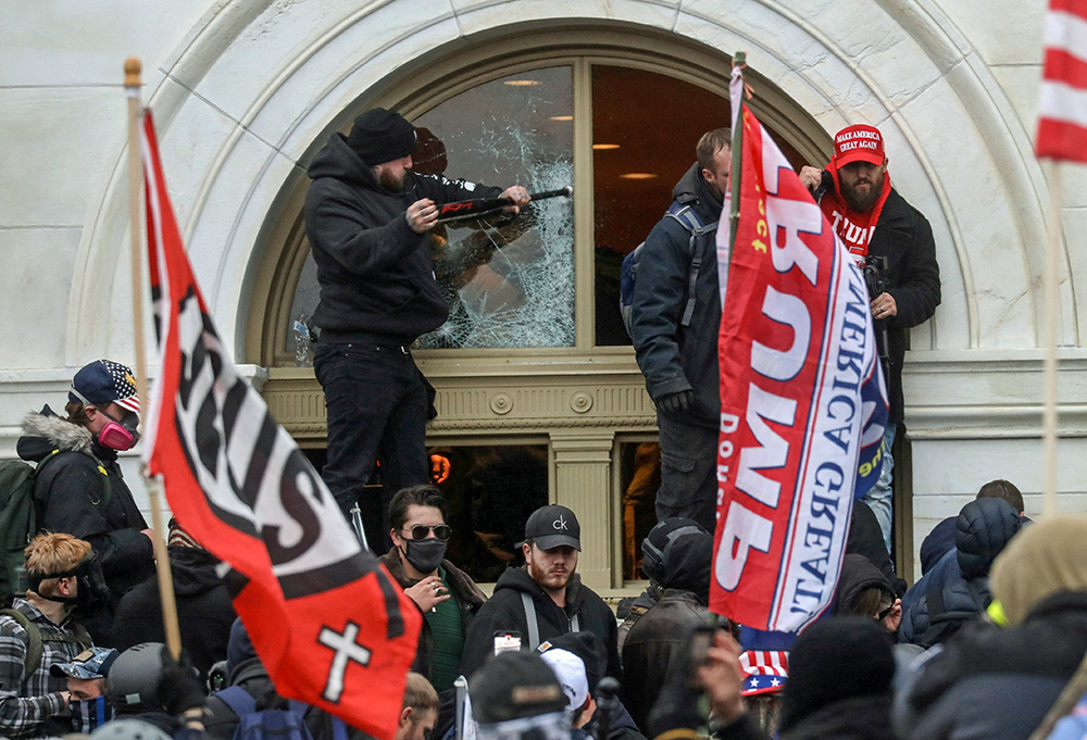 A supporter of then-President Donald Trump breaks a window at the U.S. Capitol in Washington Jan. 6, 2021. (CNS/Reuters/Leah Millis)