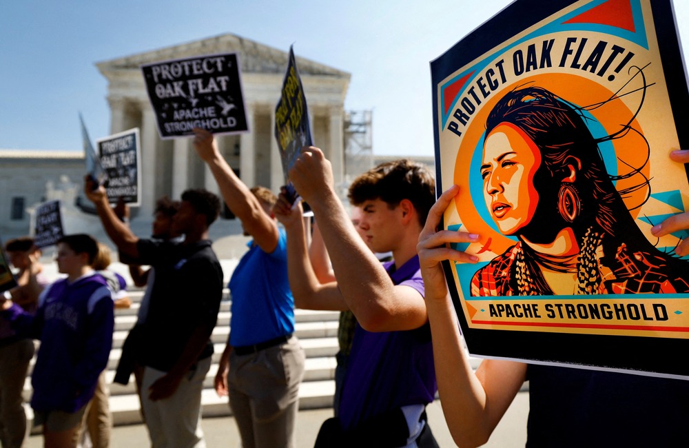 People lined up in front of court house holding signs.