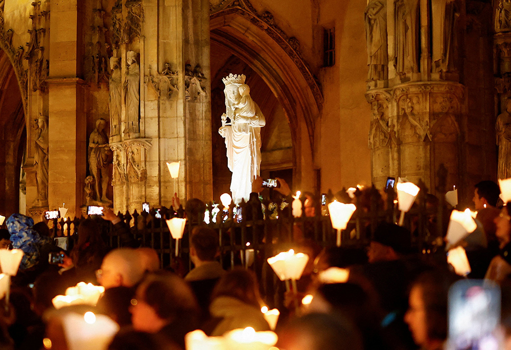 A Virgin of Paris statue replica is carried during a Marian candlelit procession through the streets of Paris Nov. 15, as the original, for security reasons, was transported on a truck back to Notre Dame Cathedral. The statue was kept at the Saint-Germain-l'Auxerrois Church near the Louvre for five years since Notre Dame was ravaged by a fire in 2019. (OSV News/Reuters/Stephanie Lecocq)