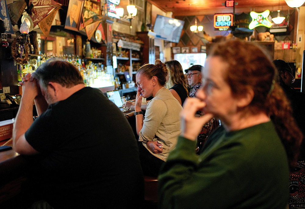 Donilee McGinnis, 42, regional organizing director for North Fulton for the Harris-Walz campaign, center, reacts at Manuel's Tavern in Atlanta while watching Democratic presidential nominee U.S. Vice President Kamala Harris deliver her concession speech at Howard University in Washington, on Nov. 6. (OSV News/Reuters/Cheney Orr)