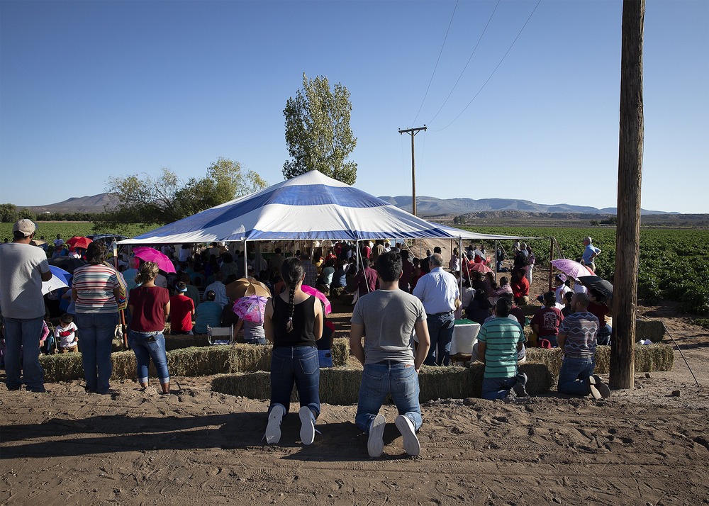 People assemble around tent.