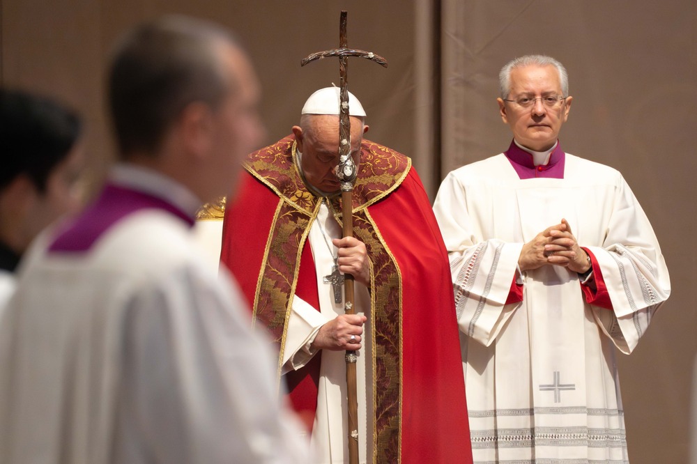 Francis, vested for Mass, prays against crozier. 