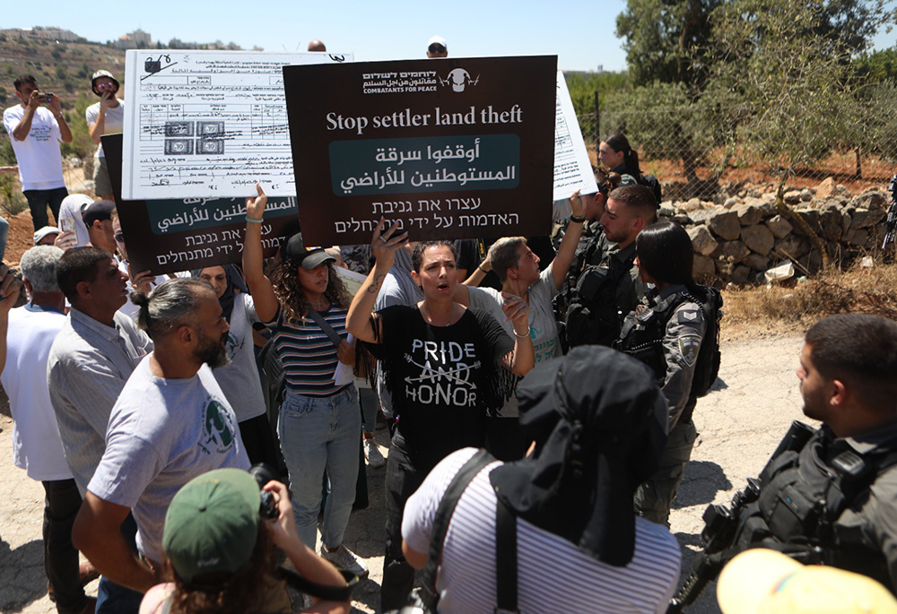 Activists and local residents formed a human wall in a nonviolent action on Aug. 8 to push Jewish settlers out of Palestinian land near Bethlehem, West Bank. (Courtesy of Amira Musallam)