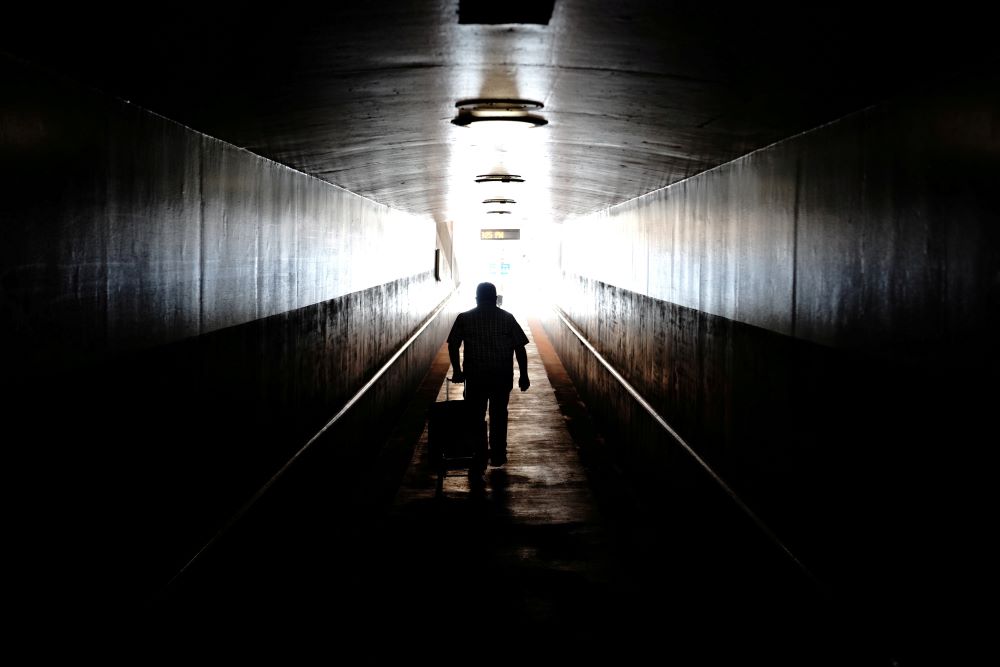 A traveler in Los Angeles pulls his rolling luggage behind him Aug. 10 as he walks toward a train platform at Union Station. The $1 trillion bipartisan infrastructure includes $66 billion in new funding for rail. (CNS/Reuters/Bing Guan)