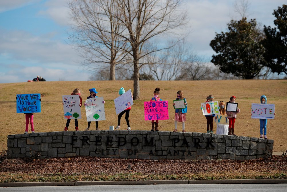 Girl Scouts in Atlanta hold signs urging residents to vote in the runoff election for both of Georgia's U.S. Senate seats Jan. 3, 2021. (CNS/Reuters/Brian Snyder)