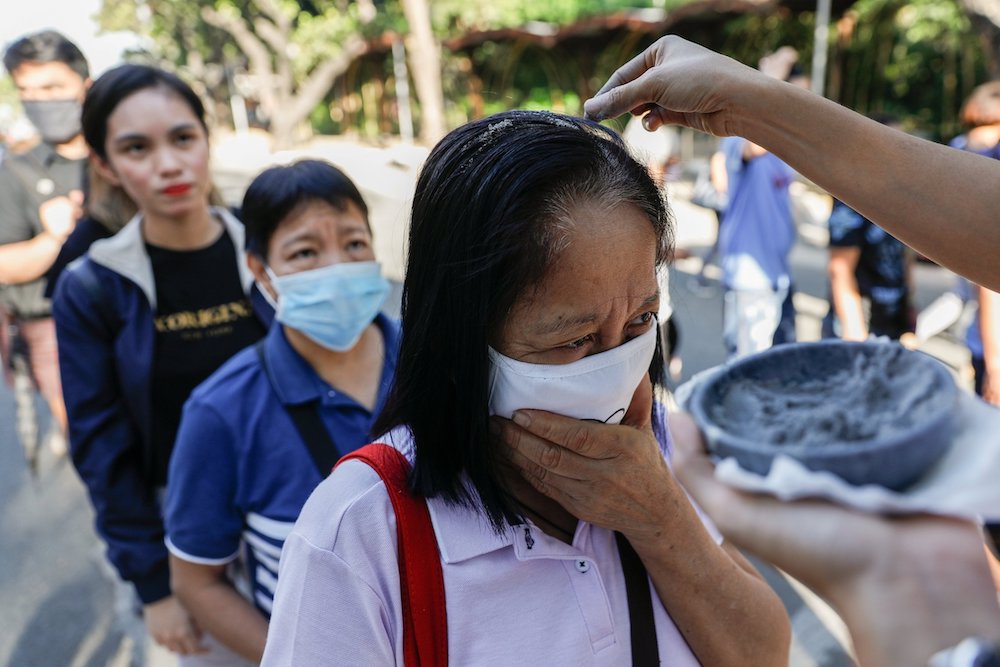 Worshippers wearing protective masks because of COVID-19 receive ashes sprinkled over their heads during Ash Wednesday Mass at the National Shrine of Our Mother of Perpetual Help in Manila, Philippines, Feb. 26, 2020. (CNS/Reuters/Eloisa Lopez)