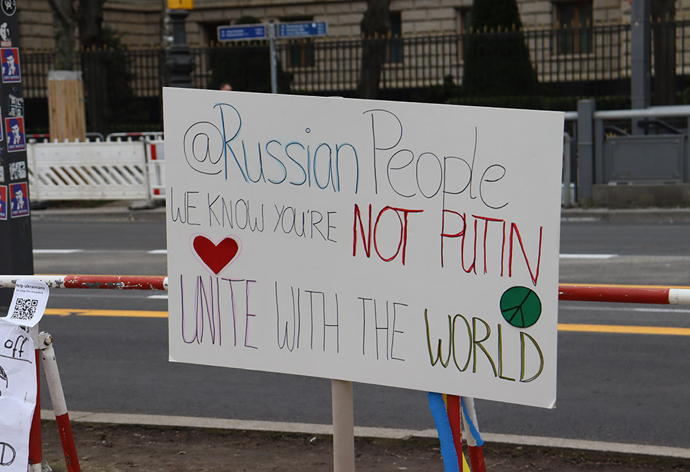 A sign decrying Vladimir Putin and the war in Ukraine is seen outside the Russian Embassy in Berlin March 4. (NCR photo/Teresa Malcolm)