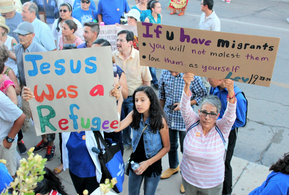 Prior to entering St. Patrick Cathedral July 20 in El Paso, Texas, people raise their banners in quiet prayer and unity. (MVO Photography/Lulu Olvera)