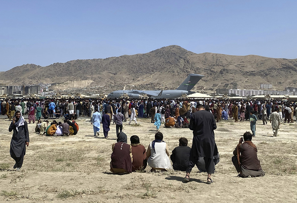 Hundreds of people gather near a U.S. Air Force C-17 transport plane at the perimeter of the international airport Aug. 16, 2021, in Kabul, Afghanistan. (AP photo/Shekib Rahmani, File)