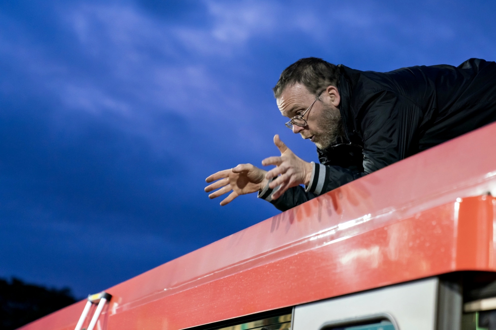 Passionist Fr. Martin Newell speaks from the roof of a train stopped at London’s Shadwell Station en route to the financial district Oct. 17. (Courtesy of Extinction Rebellion/ Vladimir Morozov)