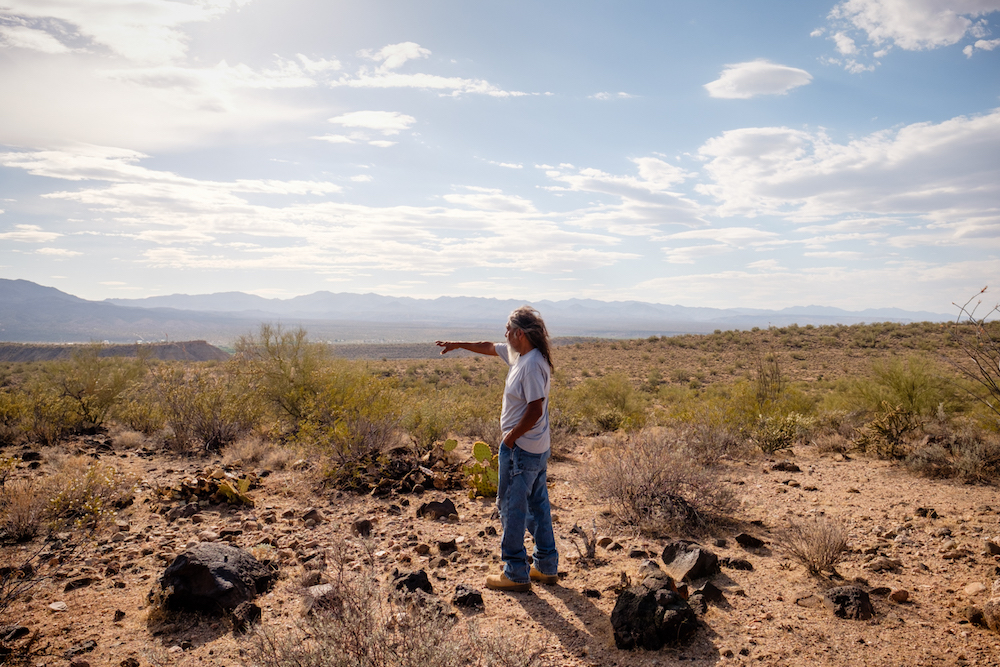 Cholla Canyon Ranch caretaker Ivan Bender points out the boundaries of the Hualapai Tribe's property from one of the initial exploratory drilling sites surrounding the ranch. (Roberto (Bear) Guerra/High Country News)