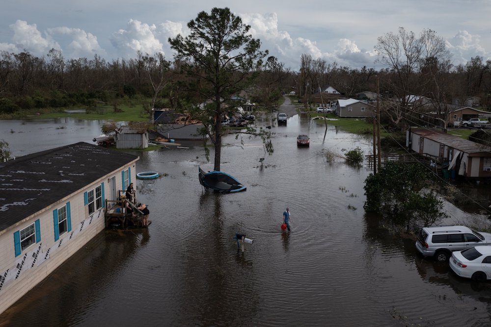 A man in Cut Off, La., walks back to his home after sharing fuel with his neighbors for their generator Aug. 30, in the aftermath of Hurricane Ida. (CNS photo/Adrees Latif, Reuters)