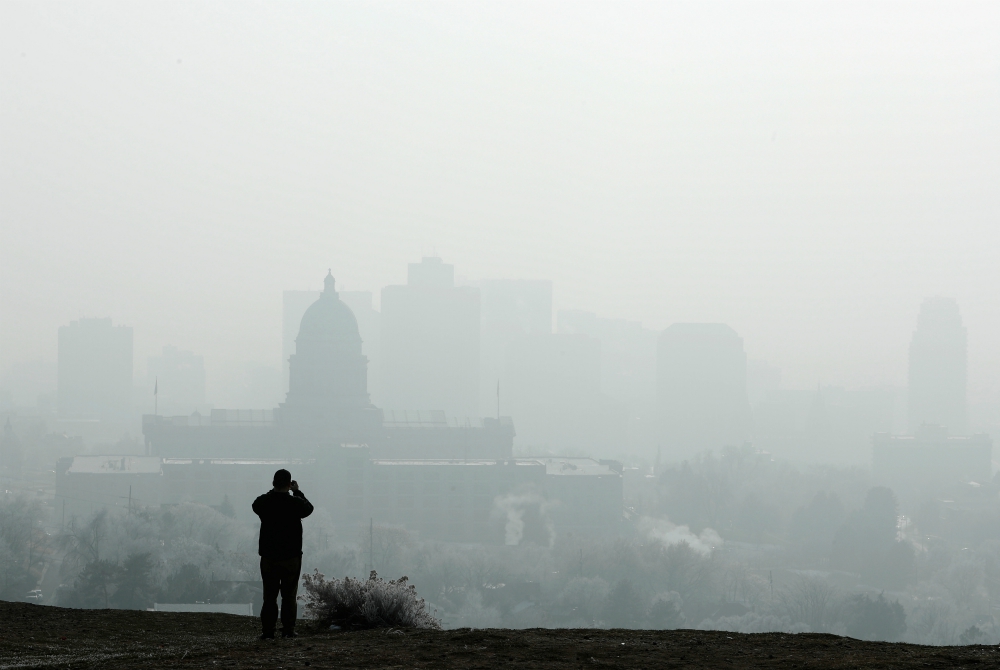 A man stops to take a picture of the Utah State Capitol and buildings that are shrouded in smog in downtown Salt Lake City Dec. 12, 2017. (CNS/Reuters/George Frey)