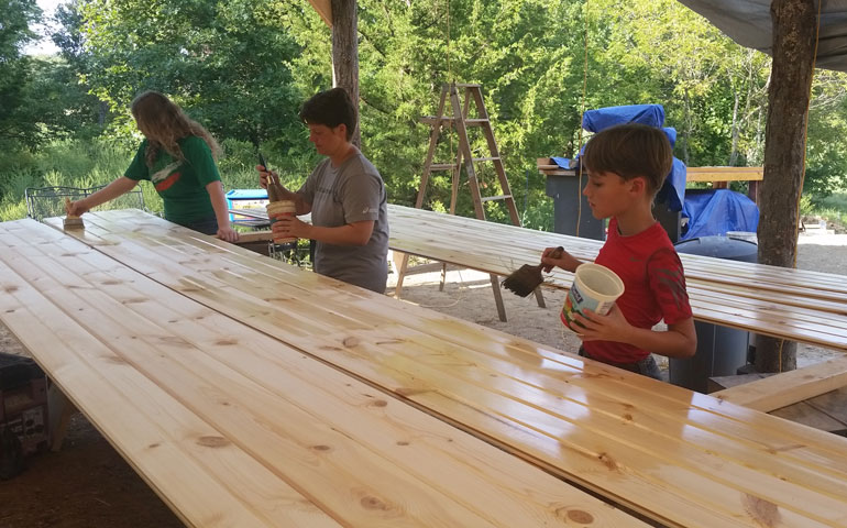 From left: Lucy, Erin and Oscar Schmidt oil wood for the ceiling of their house near Lawrence, Kan. (Courtesy of the Schmidt family)