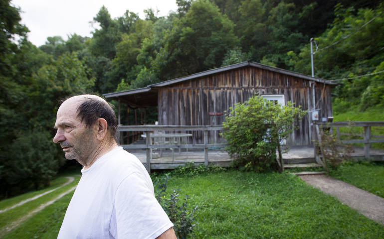 Delphin Brock looks across his yard towards a distant mountaintop removal coal mine near Kermit, W. Va., Aug. 20. Brock, 73, said he is concerned about the impact of mountaintop removal coal mining, but understands people around the world depend on West Virginia coal. (CNS photo/Tyler Orsburn)