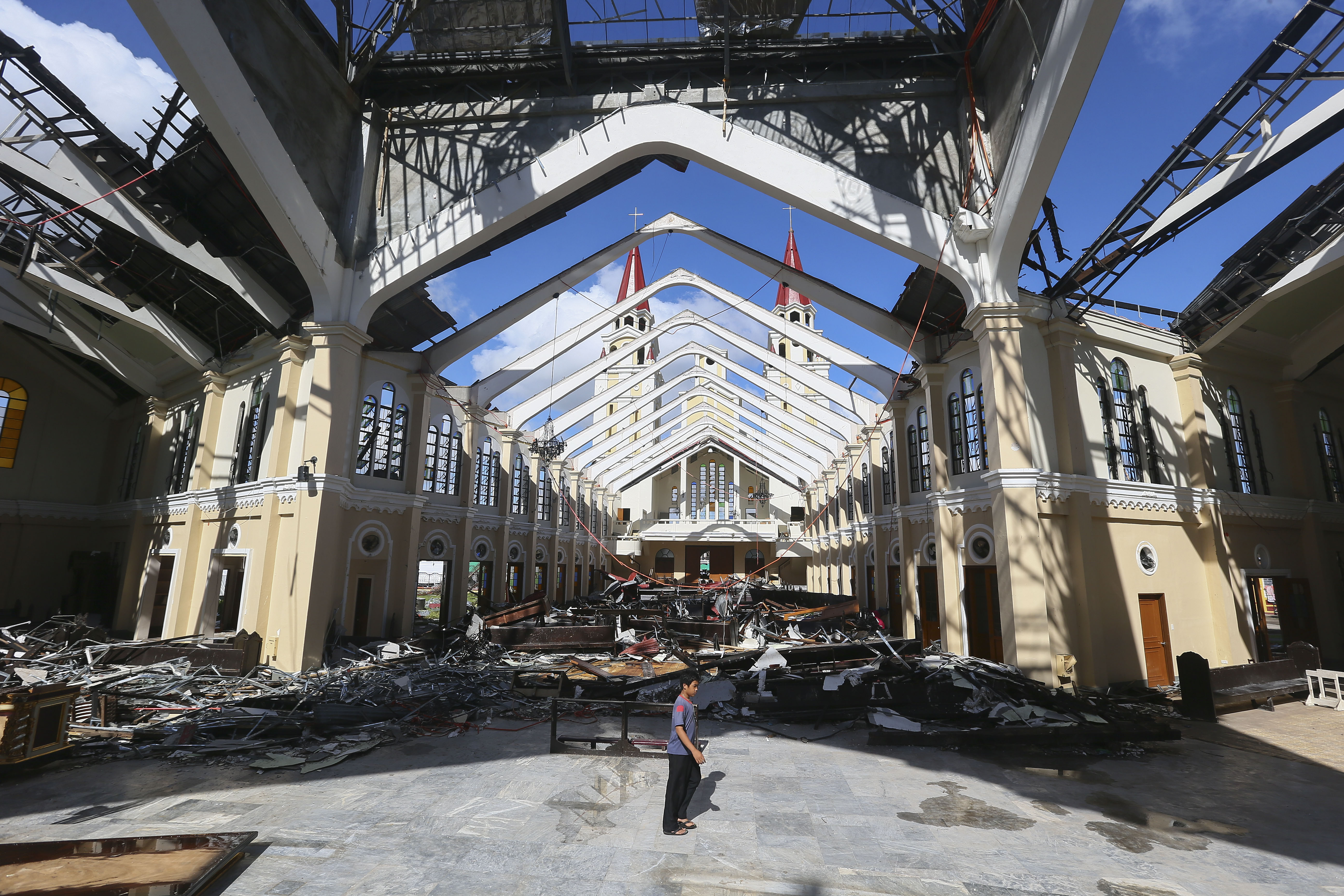 In this 2013 file photo, a Filipino boy walks in the destroyed cathedral in Palo, Philippines. The pope is scheduled to meet survivors as well as priests and religious and give a speech there Jan. 17. (CNS/EPA/Nic Bothma) 