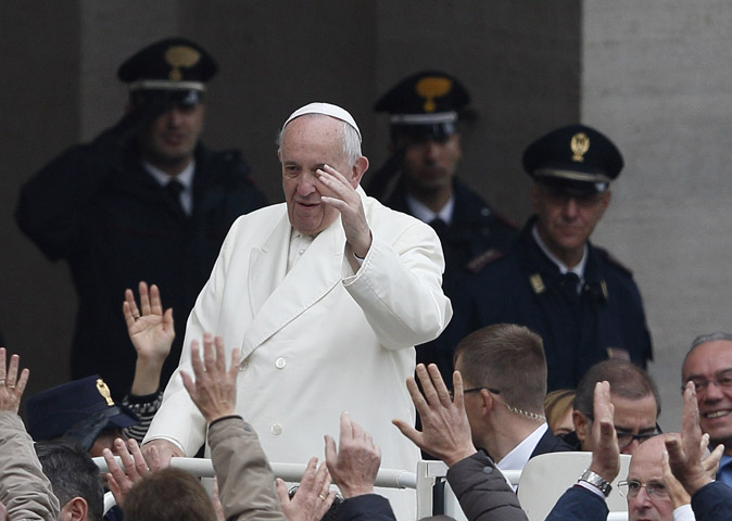 Policemen watch as Pope Francis arrives to lead his general audience in St. Peter's Square at the Vatican Nov. 18. (CNS/Paul Haring)