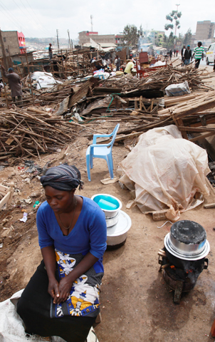 A woman cooks outside her destroyed residence after hundreds of homes were demolished in 2015 during forced evictions in Nairobi, Kenya. (CNS/Daniel Irungu, EPA)