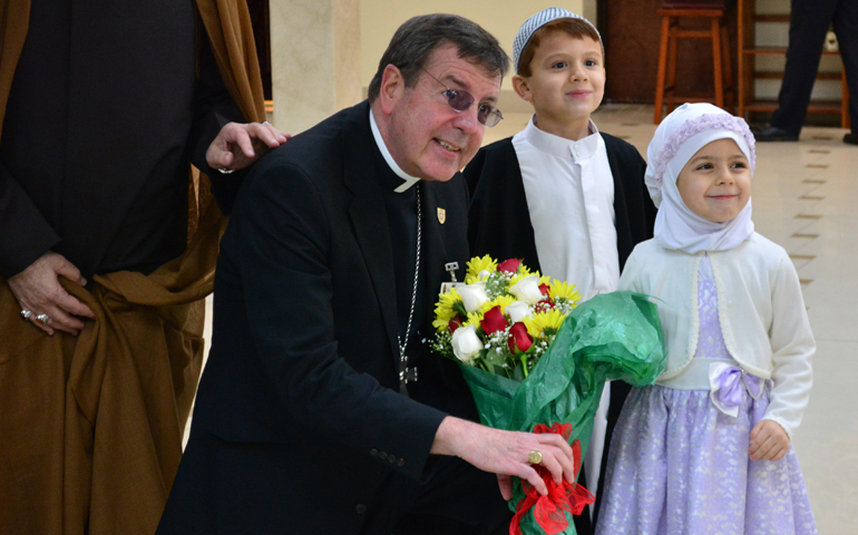 Detroit Archbishop Allen Vigneron poses April 5 with a young Muslim boy and girl during a "unity lunch" with local Muslim leaders in Dearborn, Mich. (CNS/Mike Stechschulte, The Michigan Catholic)