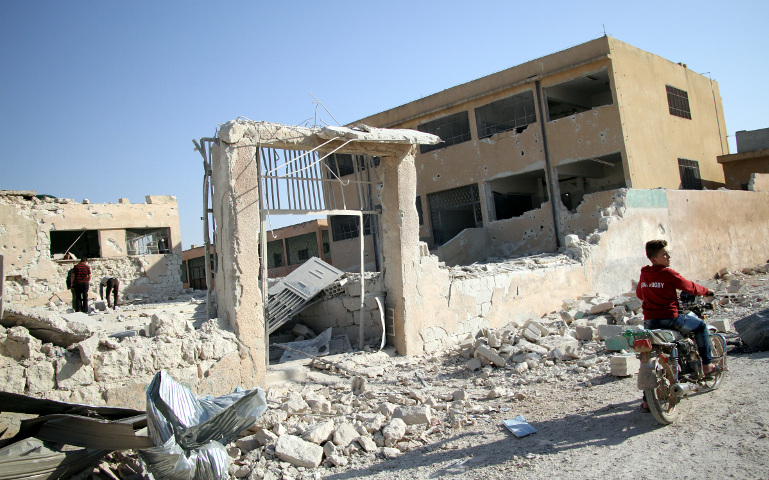 Syrians check a school Oct. 27 that was bombed a day earlier in the rebel-held province of Idlib, Syria. (CNS/Reuters/Abed Kontar) 