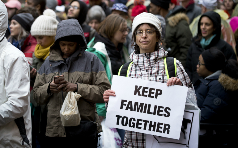 A woman holds a pro-immigration sign in Washington prior to the start of U.S. President Donald Trump's swearing-in as the country's 45th president Jan. 20. (CNS photo/Tyler Orsburn)