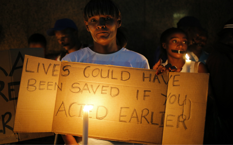 People gather to hold a candle vigil Feb. 2 in Johannesburg for the 94 mentally ill patients who died last year due to negligence. South Africa's Jesuit Institute said it is appalled at government actions that led to the deaths of the patients in Gauteng province, and the bishops' justice and peace commission called for compensation to affected families. (CNS photo/Kim Ludbrook, EPA)