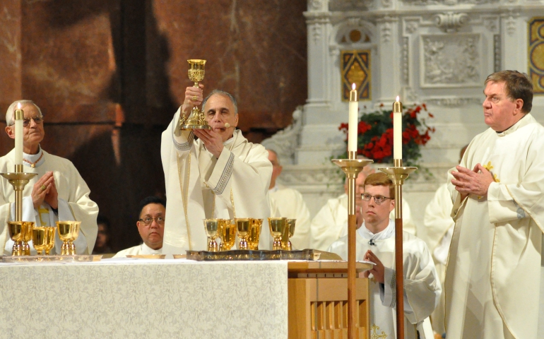 Cardinal Daniel DiNardo of Galveston-Houston elevates a chalice during a June 14 Mass at Sts. Peter and Paul Cathedral in Indianapolis. Concelebrating the Mass is Washington Cardinal Donald Wuerl, left, and Cardinal Joseph Tobin, right, of Newark, New Jersey. (CNS/The Criterion/Sean Gallagher)