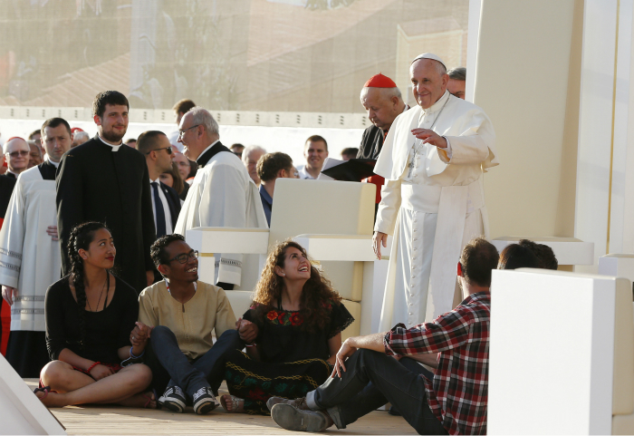 Pope Francis waves after inviting World Youth Day pilgrims to sit in front of his chair during the July 30 prayer vigil at the Field of Mercy in Krakow, Poland. (CNS photo/Paul Haring)