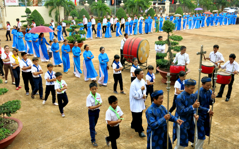 Catholics march in procession into a church in Binh Phuoc province on May 26, when they welcomed a new parish priest. (Contributed photo)