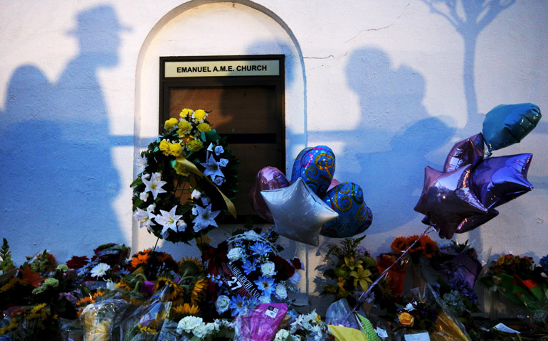 Mourners cast shadows on the wall of a makeshift memorial June 18 at the Emanuel African Methodist Episcopal Church in Charleston, S.C. (CNS/Reuters/Brian Snyder)