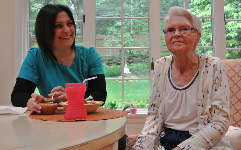 Maka Anguladze, left, feeds Vickie breakfast at the Leach household. (Jessica Hinderliter)