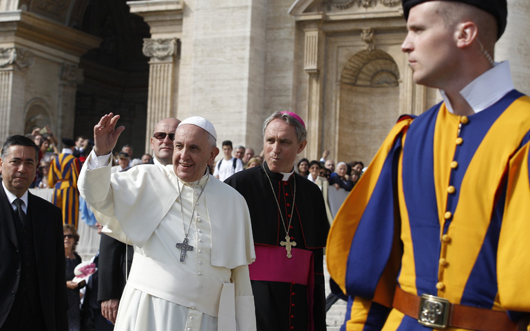 A Swiss Guard keeps watch as Pope Francis greets the crowd during his general audience Wednesday in St. Peter's Square at the Vatican. (CNS/Paul Haring) 