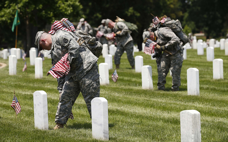 Members of the Third U.S. Infantry Regiment take part in a "Flags-In" ceremony Thursday at Arlington National Cemetery near Washington. The soldiers placed American flags in front of more than 220,000 graves. (CNS/Reuters/Kevin Lamarque)