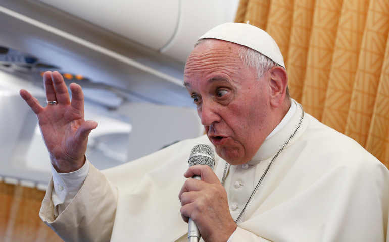 Pope Francis answers questions from journalists aboard his flight from Yerevan, Armenia, to Rome June 26. (CNS/Paul Haring)