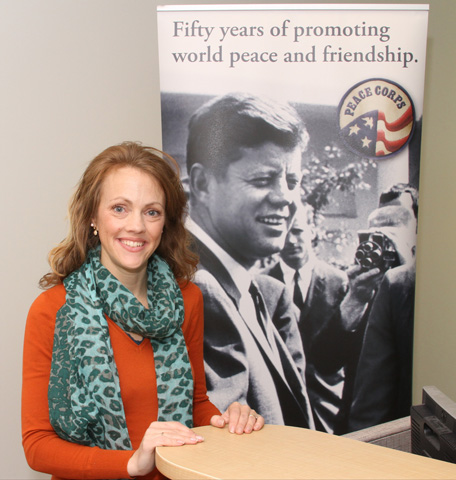 Monica Oliver, who served in West Africa's Republic of Mali with the Peace Corps from 2000 to 2002, poses near an image of President John F. Kennedy on Nov. 14 in Atlanta. (CNS/Georgia Bulletin/Michael Alexander)