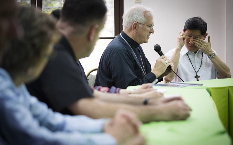 Philippine Cardinal Luis Tagle of Manila wipes away tears as he discusses Typhoon Haiyan damage Tuesday with Archbishop Joseph Kurtz, president of the U.S. Conference of Catholic Bishops, in Manila, Philippines. (CNS/Tyler Orsburn) 