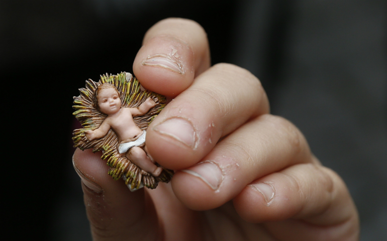 A girl holds her baby Jesus figurine as Pope Francis leads the Angelus from the window of his apartment overlooking St. Peter's Square at the Vatican Dec. 11. In an annual tradition, Roman children brought their figurines of the baby Jesus to the Angelus. (CNS photo/Paul Haring)