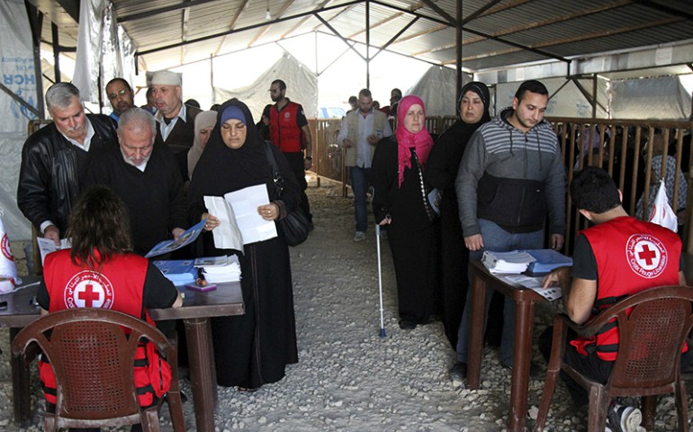 Syrian refugees line up to receive aid for the winter from the U.N. refugee agency (UNHCR) in Tripoli, northern Lebanon, on Nov. 18, 2015. (Omar Ibrahim/Reuters)