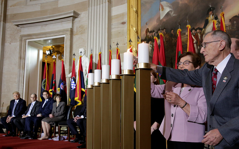 U.S. President Donald Trump, far left, looks on as Holocaust survivors light candles during the U.S. Holocaust Memorial Museum's "Days of Remembrance" ceremony in the The Capitol Rotunda on Capitol Hill, in Washington, D.C., on April 25, 2017. (Reuters/Yuri Gripas)